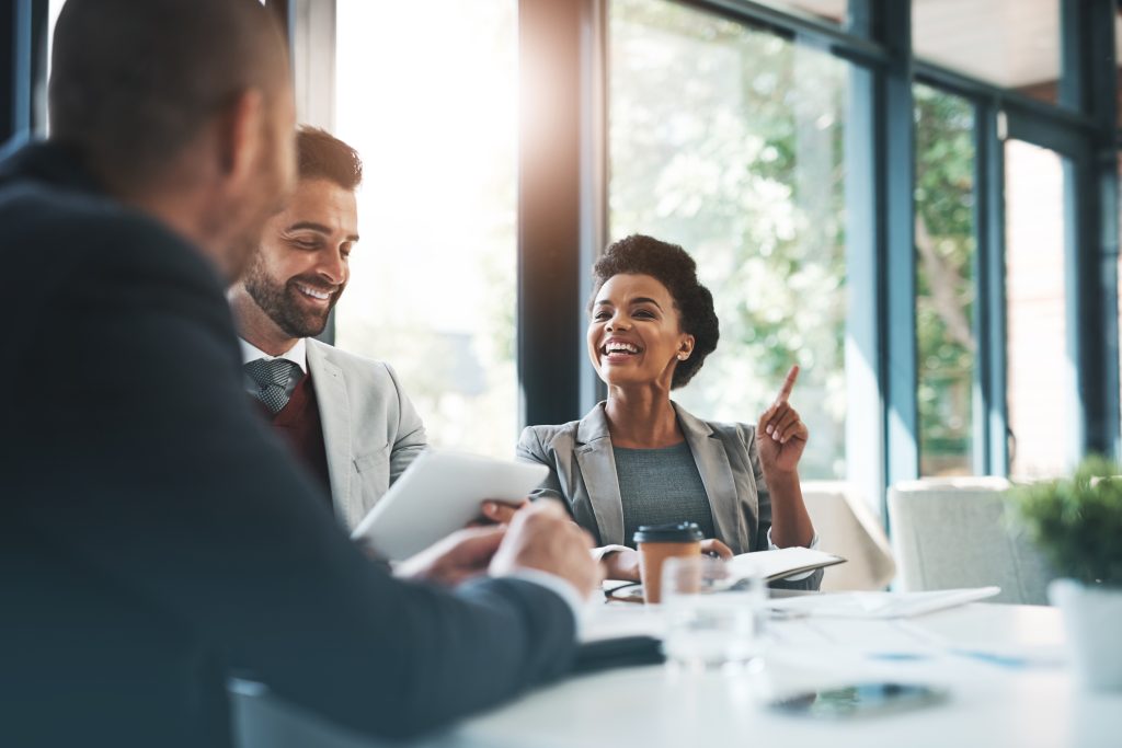 the sun coming through a window illuminating people sitting at a conference table