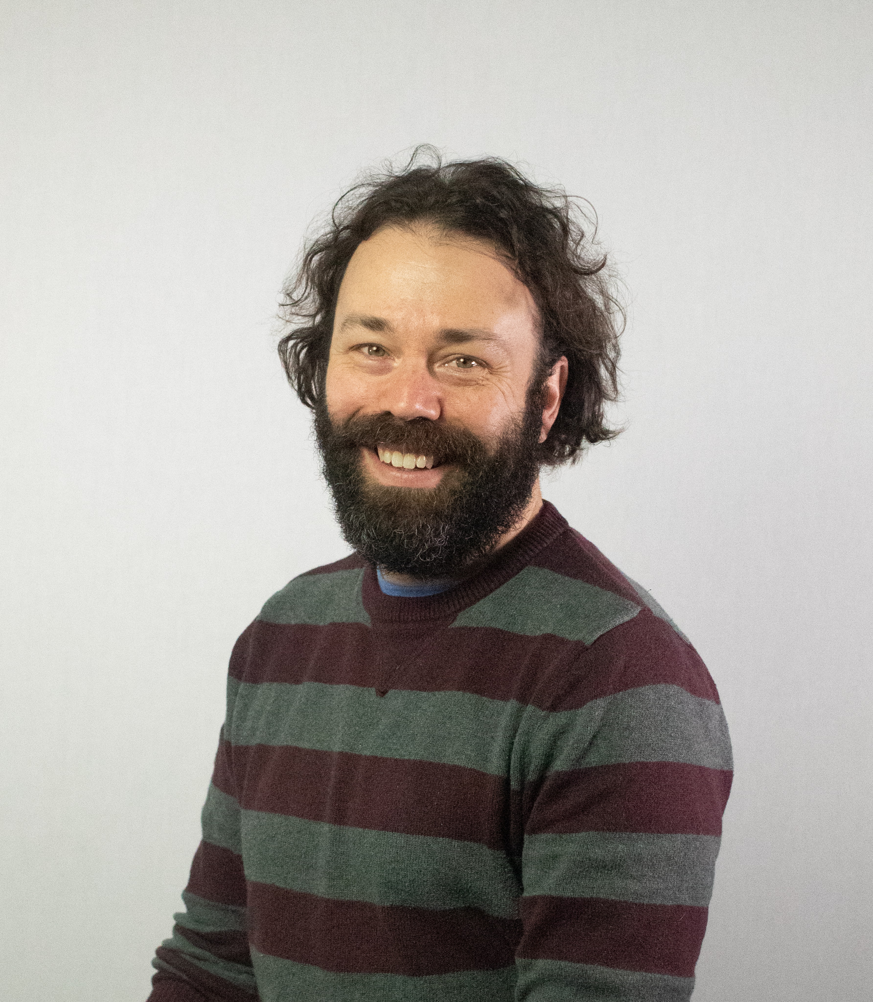 Photo of the author Steve Scaduto. Male, wavy long-ish brown hair, beard and mustache, visibly presenting as white, smiling toward camera.