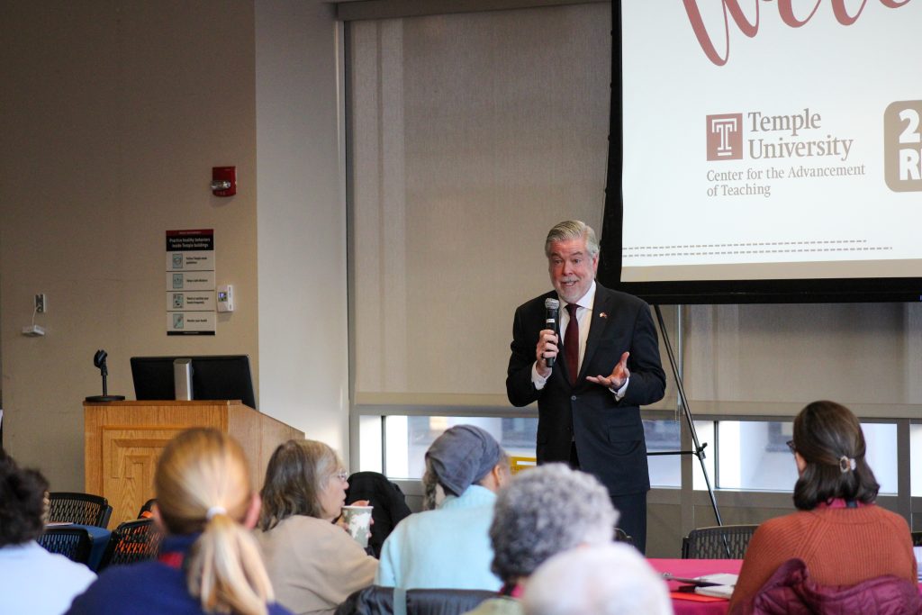 President Fry addressing the conference room with microphone