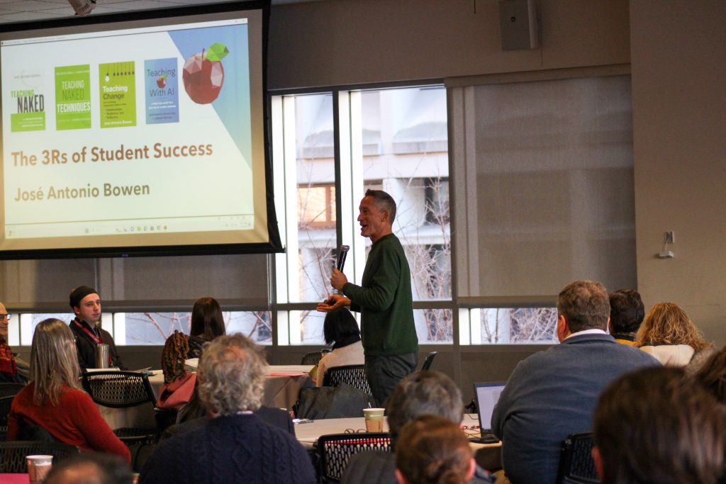 Jose Bowen presenting to filled room with attendees and tables