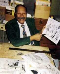 Photograph of Samuel Joyner holding up a cartoon