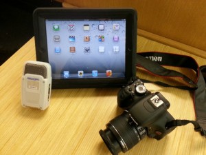 a digital slr camera, an ipad, and a digital recorder.
