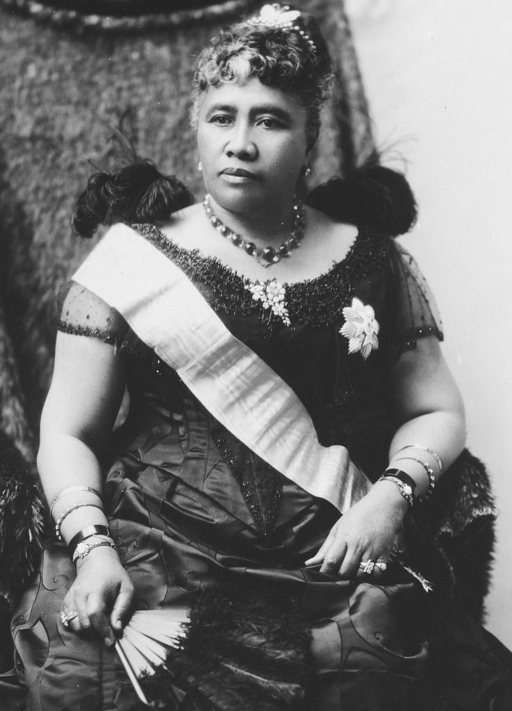 A middle-aged Hawaiian woman richly dressed in western-style clothes posing for a photograph.