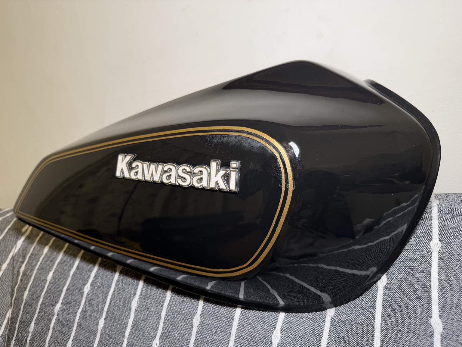 Close-up of the black KZ650 fuel tank with gold pinstripes and a Kawasaki badge.