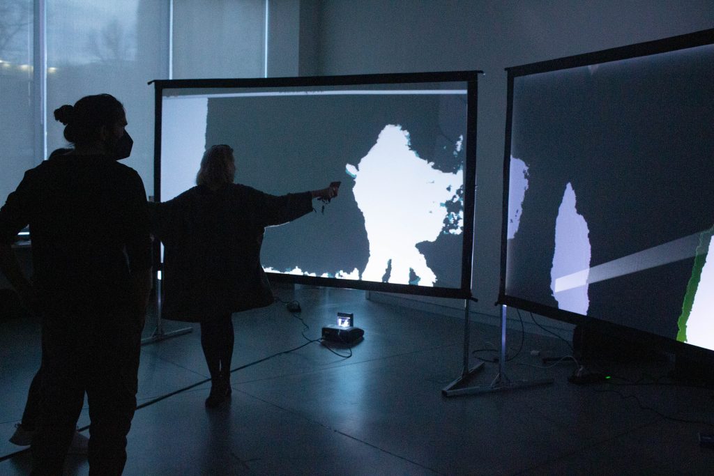 Students in silhouette in front of projection screen