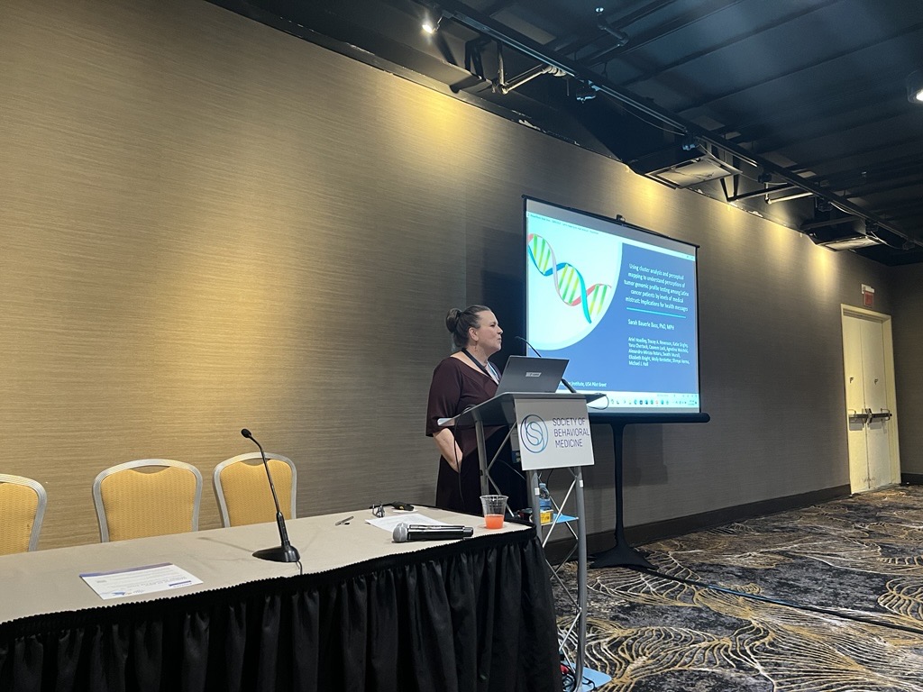 Dr. Sarah Bass presenting findings on attitudes towards genetic testing among diverse cancer populations at a symposium within the Society for Behavioral Medicine Conference, 2024
