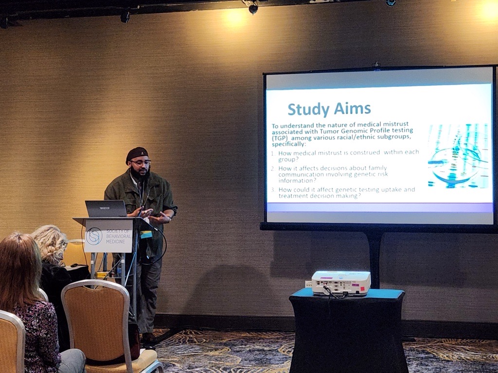 RCL Research Coordinator Caseem Luck presenting findings on attitudes towards genetic testing among diverse cancer populations at a symposium within the Society for Behavioral Medicine Conference, 2024